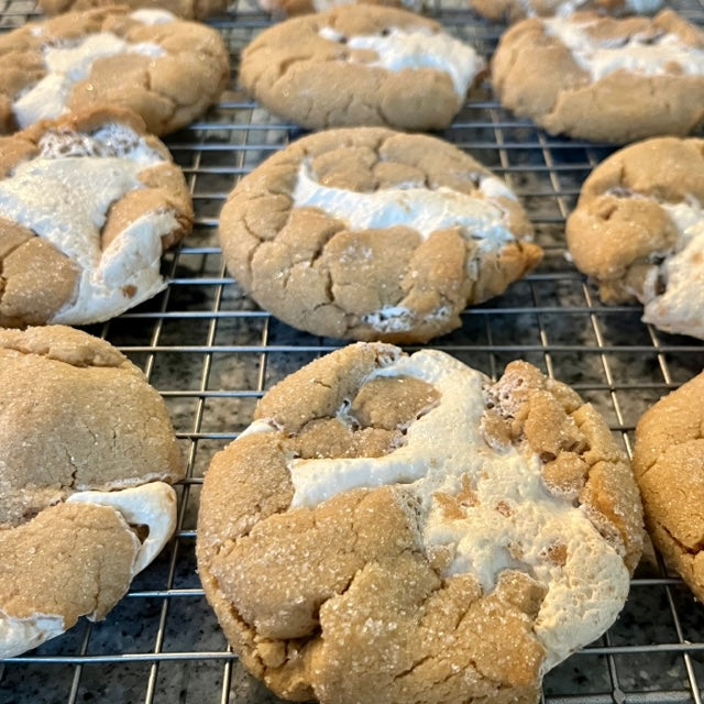 Rows of peanutbuttery, marshamallow stuffed cookies on a baking rack.