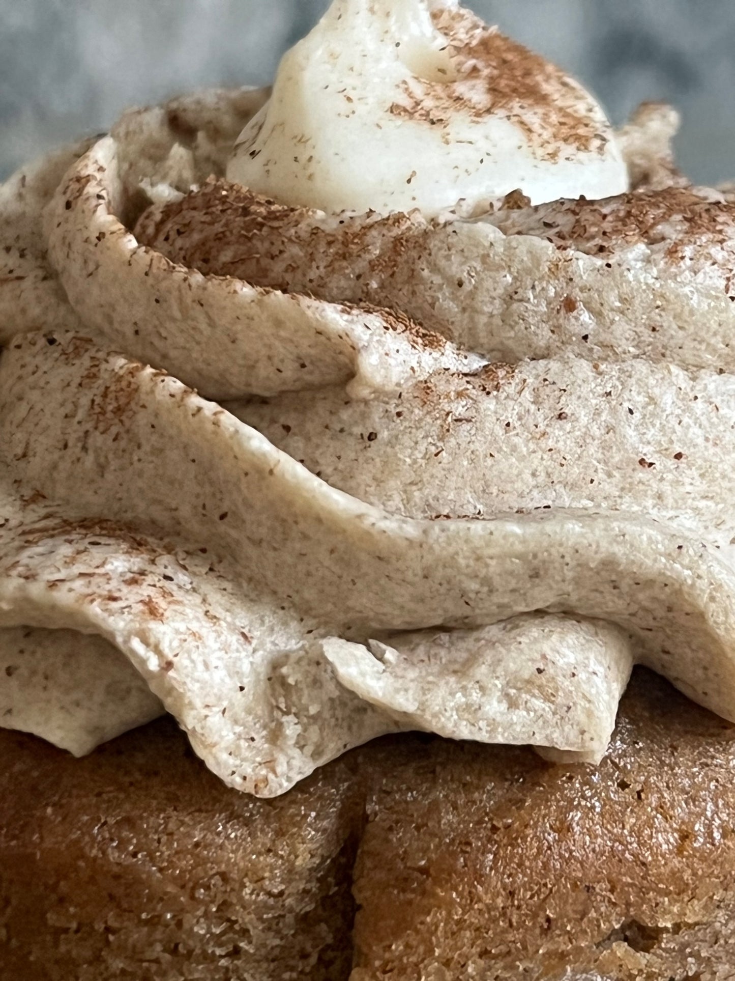 A close up image of the intricate layers of the ribboned frosting on a Chai Honey Bear Cupcake.