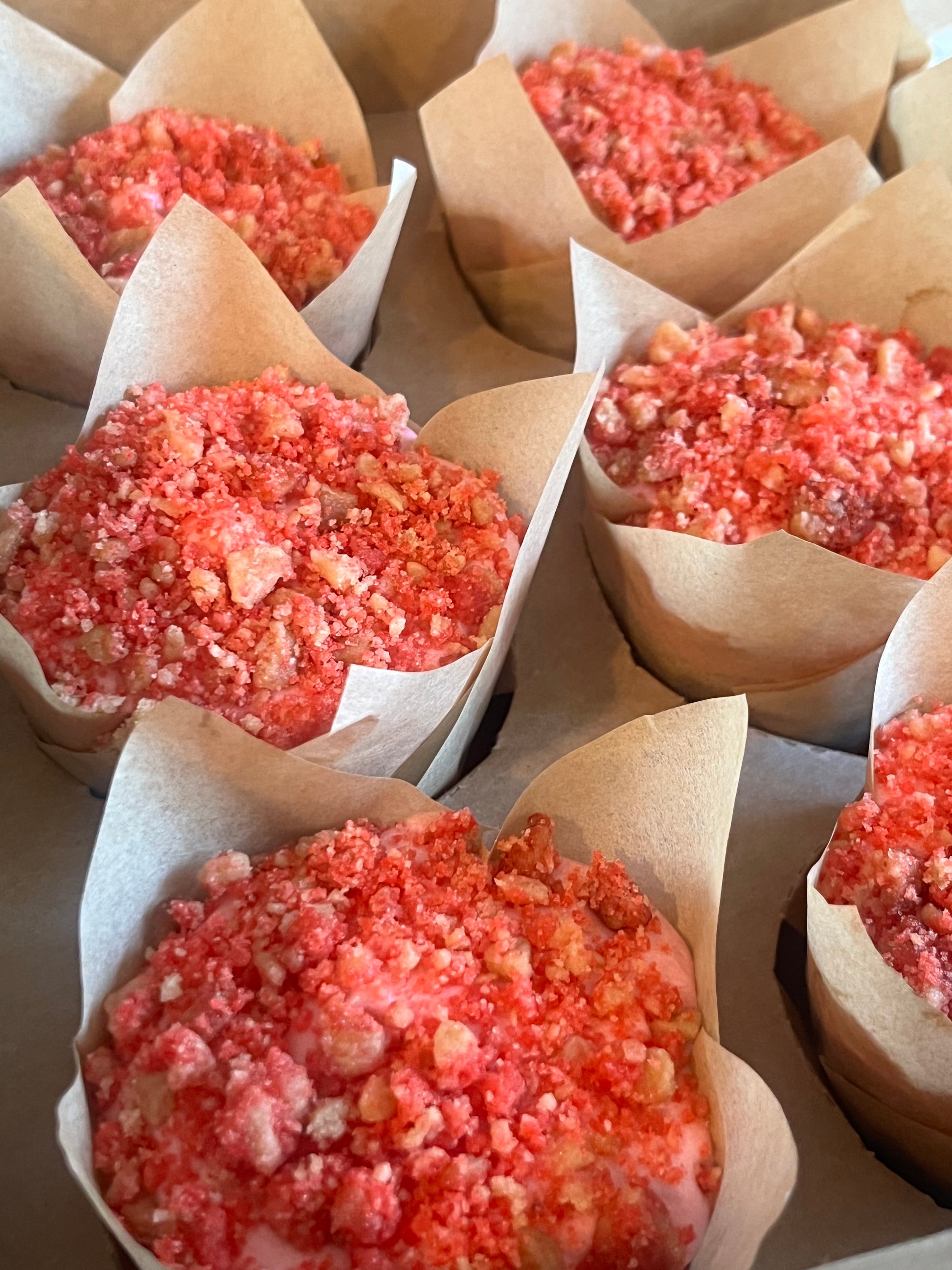 Six Strawberry Shorty Cupcakes sitting in a bakery box.